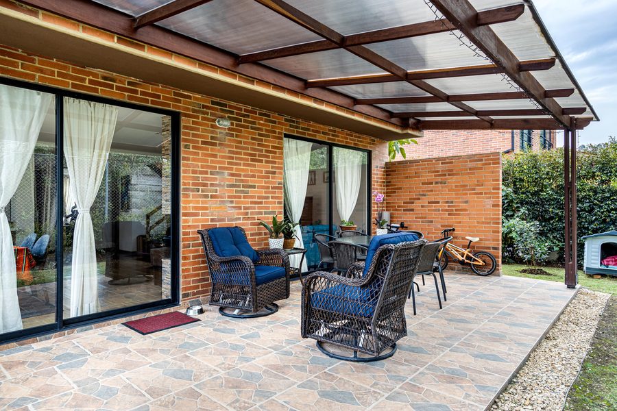Terrasse extérieure carrelée avec salon de jardin